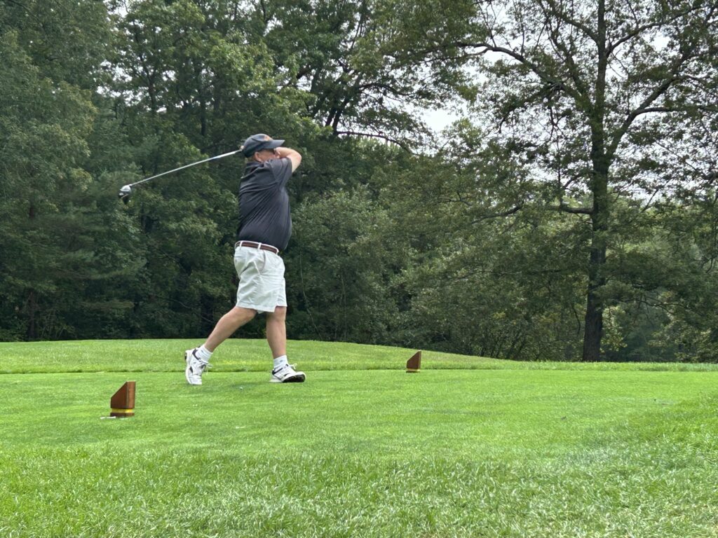 Man on a golf course hitting a ball.